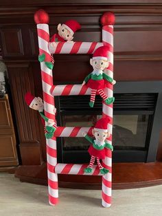 two elfs are on top of candy canes in front of a fireplace