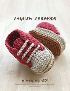 two crocheted baby shoes sitting on top of a wooden floor next to each other