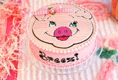 a pink cake with a pig face on it's frosting sitting on a table