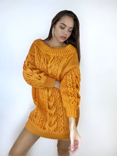 Oversized sweater-dress made of soft, body-friendly merino wool blend yarn, with open shoulders and puffed sleeves. You can order this sweater in a long sweater dress version or in a regular size 60cm sweater. In the photo, the model is 170 cm tall, size S-M, wearing a sweater in size L, color orange -837. Size options: Size XS-S: Width - 45 cm, Length - 70-71 cm. Size M: Width - 50 cm, Length - 75 cm. Size L: Width - 55-57 cm, Length - 77 cm. Size XL: Width - 58-60 cm, Length - 77 cm. Size XXL: Oversized Cable Knit Sweater Dress For Fall, Cozy Oversized Cable Knit Sweater Dress, Oversized Knitted Sweater Dress, Cozy Chunky Knit Dress, Wool Sweaters Womens, Sweater Dress Oversized, Long Sweater Dress, Halloween Sweater, Cable Sweater