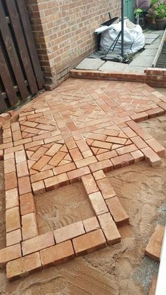 a brick patio being laid out in front of a house