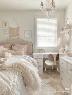 a white bedroom with a chandelier hanging from the ceiling