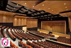 an empty auditorium with rows of seats in front of the stage and wooden walls on both sides