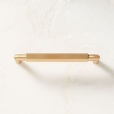 a gold handle on a white wall