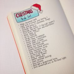 a christmas list in a notebook with santa hat on the top and writing underneath it