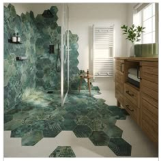 a bathroom with green tiles on the floor and walls, along with a wooden cabinet