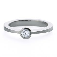 a white gold ring with a single diamond in the center and a thin band around it