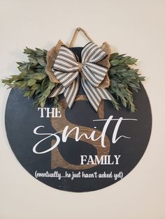 a sign that says the smith family with a bow hanging on it's side