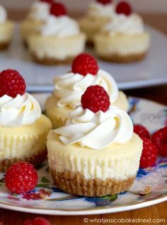 three cupcakes with white frosting and raspberries