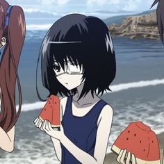 three girls standing on the beach with watermelon slices in their hands