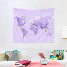 a living room with a white couch and a purple map on the wall above it