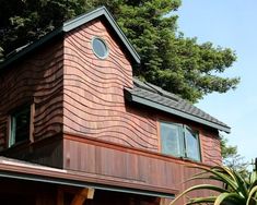 a red brick house with green trees in the background