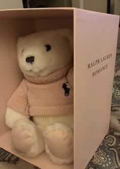 a white teddy bear in a pink box