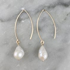 Elevate your style with our Baroque Pearl Earrings, crafted from lustrous freshwater white pearls and set in elegant 14k yellow gold-filled dangle settings.  These earrings blend boho charm with minimalist sophistication, perfect for adding a touch of timeless grace to any outfit.  Embrace the unique beauty of baroque pearls and the luxury of gold-filled craftsmanship for a statement piece that's both versatile. Features:  Natural baroque freshwater white fireball pearl Approx.  8mm -10mm x 6mm - 7mm  Perfect for mothers day, anniversary, graduation, friendship gift, birthday, wedding, bridal, bridesmaid or for tropical beach vacation Please note that pearls used are natural and have surface blemishes,  which indicates they are real, one of a kind and add uniqueness to every piece.  It may Real Pearl Earrings, Boho Minimalist, Baroque Pearl Earrings, Wedding Gifts For Bridesmaids, Unique Beauty, Wedding Bridesmaid, Friendship Gifts, Baroque Pearls, Bridesmaid Gift