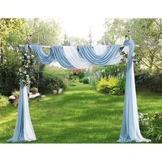 an outdoor wedding ceremony with blue drapes and flowers