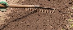 a person is holding a shovel and digging in the ground with dirt on both sides