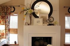 a living room filled with furniture and a fire place in front of a mirror on the wall