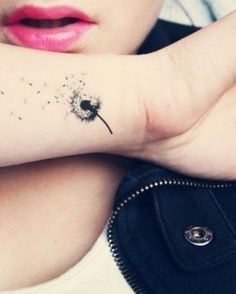 a girl with a dandelion tattoo on her arm and the words make a wish