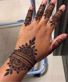 a woman's hand with henna tattoos on it