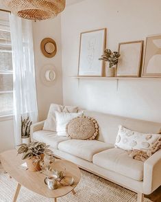 a living room with a couch, coffee table and pictures on the wall above it