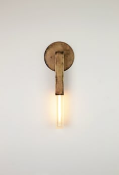 a light that is on the side of a wall with a white wall behind it