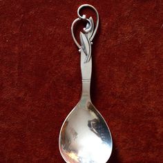 a spoon with a silver handle on a red surface