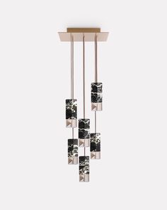 a chandelier hanging from the ceiling with black and white tiles on it's sides