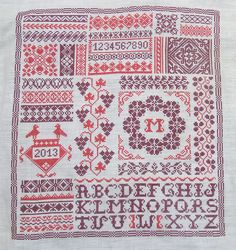 a cross stitch pattern with the letters and numbers in red on white linen, which has been embroidered onto it