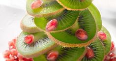 a bunch of kiwi slices stacked on top of each other with pomegranates