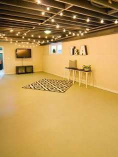 an empty room with lights on the ceiling and a black and white rug in front of it