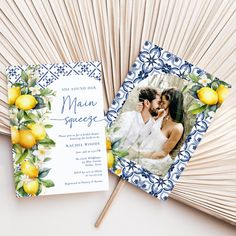 the wedding card has lemons on it and is next to a fan with an image of two people