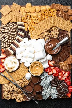 an assortment of cookies, marshmallows, and other treats on a board