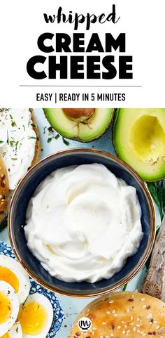 an image of whipped cream in a bowl surrounded by bagels and avocados