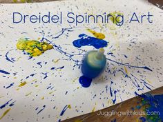 an art project with blue and yellow paint splattered on the paper that says dreidel spinning art