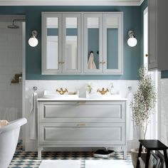 a bathroom with blue walls and white cabinets