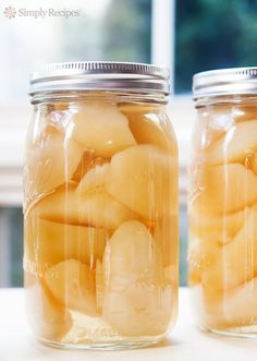 two jars filled with sliced bananas on top of a white countertop next to a window