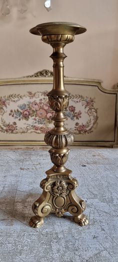 an antique brass candle holder on a marble floor