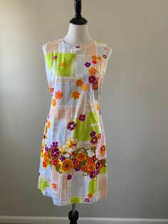 1960s-70s vibrant floral Longe Craft shift dress. The perfect dress for summer vacation! The cotton dress has pops of purple, hot pink, orange, olive green, and yellow flowers set against a beige, light blue, and lime green geometric background. Perfect for the beach, lounging around the house, or summer weekend fun. The dress zips up the back and has pockets. The cotton is sheer. Union made in the USA. Condition: Excellent vintage condition. Measurements: Size: small. Measurements taken when ga Mod Summer Beach Dresses, Summer Mod Beach Dresses, 1970s Multicolor Summer Dresses, Multicolor 1970s Summer Dresses, Summer Multicolor Mod Dresses, Multicolor Mod Summer Dress, Multicolor Mod Style Summer Dresses, 1970s Style Orange Summer Dress, 1970s A-line Summer Dress