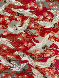 a red and gold fabric with cranes on it