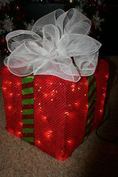 a present wrapped in red and green paper with a white bow on it's top