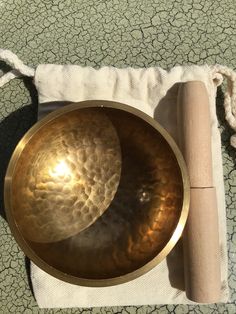 a gong sitting on top of a cloth next to a roll of paper and a wooden stick