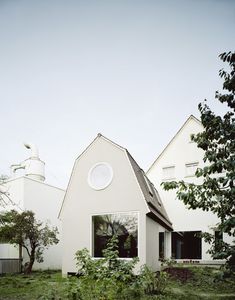 a white house sitting on top of a lush green field