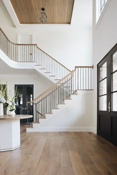 a white staircase with wooden handrails leading up to the second floor