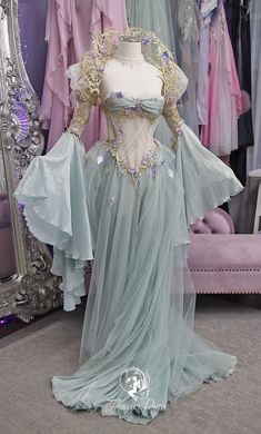 a dress that is on display in front of a mirror with other dresses behind it