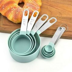 measuring spoons, measuring cups and measuring utensils are on a cutting board