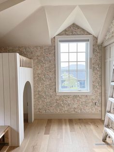 an empty room with wooden floors and wallpaper on the walls is pictured in this image