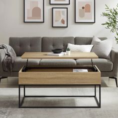 a living room with a couch, coffee table and pictures on the wall above it