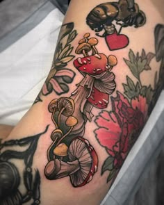 a close up of a person's arm with mushrooms and flowers on the side