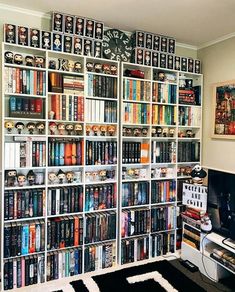 a bookshelf filled with lots of books next to a black and white rug