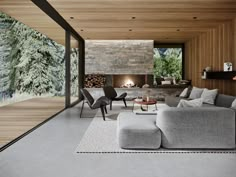 a living room filled with furniture and a fire place next to a wall covered in wood